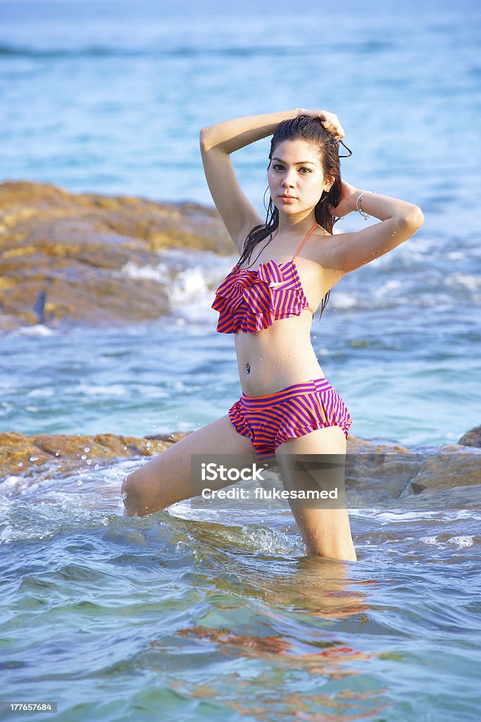 Bella donna in bikini sulla spiaggia in un giorno d'estate - Foto stock royalty-free di Acqua