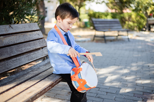 boy playing trumpet in the park