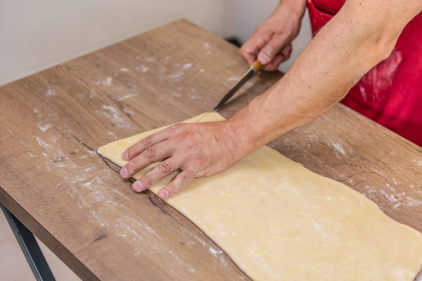 istock Chef is creating croissants. Hands are cutting dough by knife. 1776603174