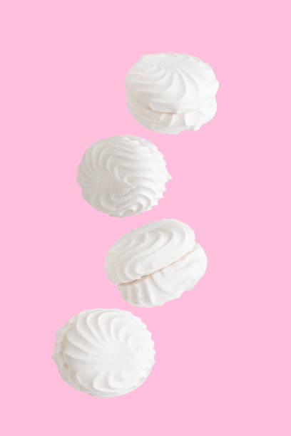 istock Soaring white zephyr marshmallow on pink background, food levitation 1776657323