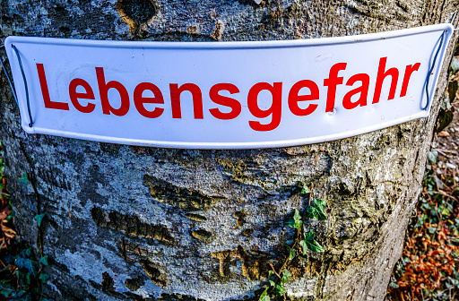 danger sign at a hiking path in germany - on own risk