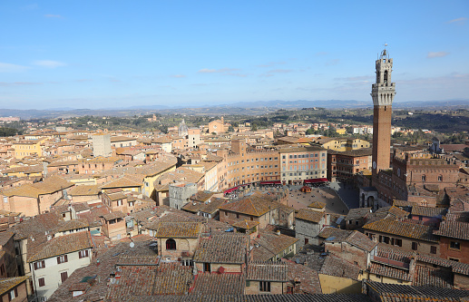 civic tower called Torre del Mangia and panorama of the city of Siena in Tuscany in Italy