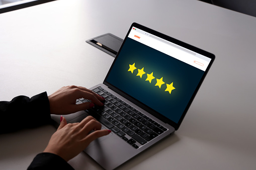 Woman's hands are using laptop and giving rating on web page
