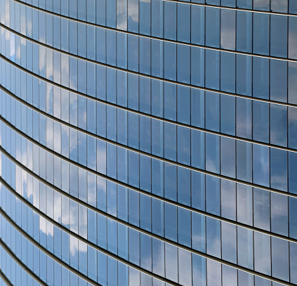 background of many windows with cloud reflections on the glass of a modern building in the metropolis