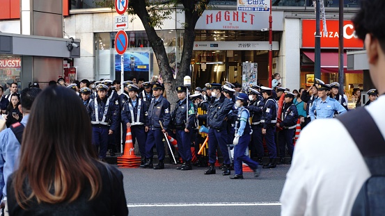 Shibuya, Japan – October 28, 2023: Shibuya, Tokyo, Japan - October 28 2023 district during Halloween, a significant police presence ensures public safety, reflecting the city's commitme