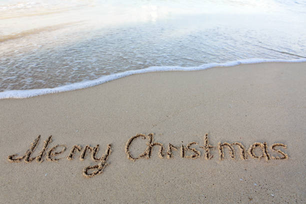 Merry Christmas text on the sea beach. stock photo