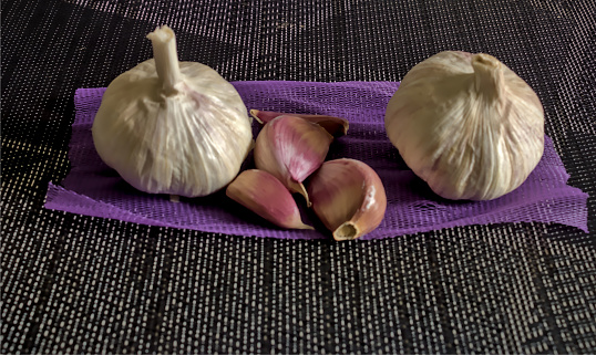 natural garlic rich in vitamins on a pink and black background