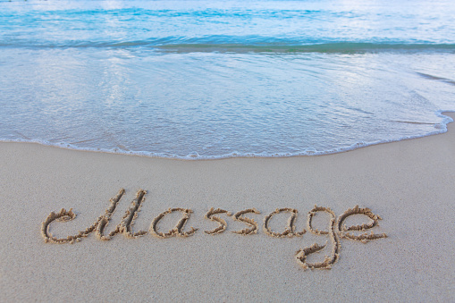 Word massage written on the sand of the beach. Beach and wave background.