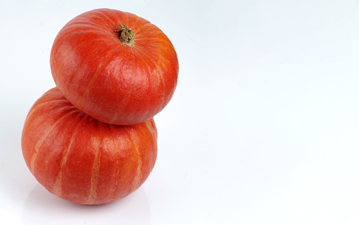 Two red kuri squash isolated on a white background.