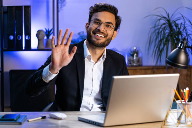 istock Businessman working on laptop smiling friendly at camera and waving hands gesturing hello at office 1776799332