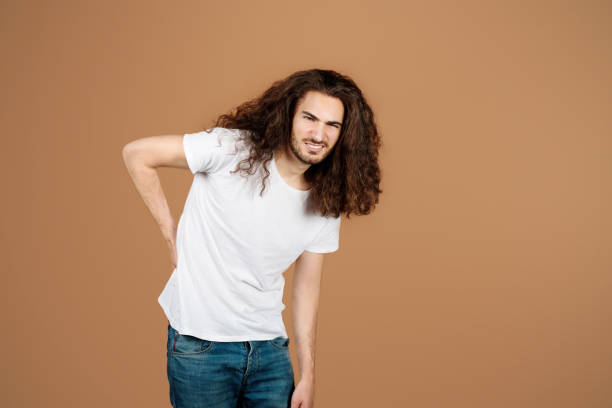 istock Hispanic guy touching back suffering from pain over beige background 1776806209