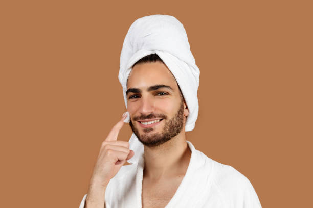 istock Arabic Guy Applying Cream On Face Moisturizing Skin, Brown Background 1776806210