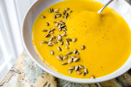 Blended pumpkin puree soup made with coconut milk, pumpkin, onions and garlic