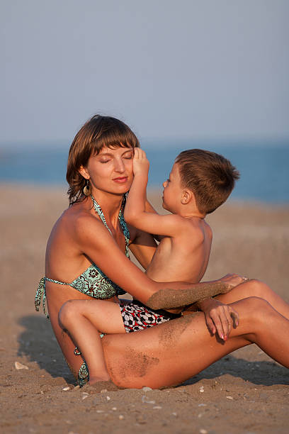 Mother and son on the beach stock photo