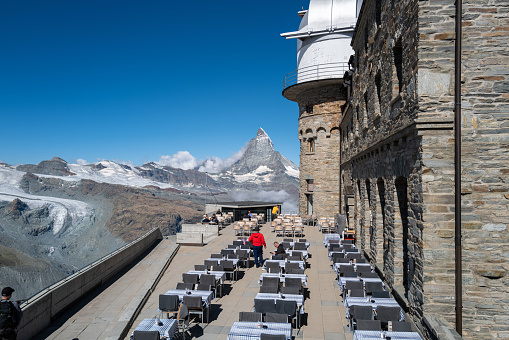 Gornergrat, Switzerland - July 6, 2022: Theodul Glacier and Matterhorn view from the Gornergrat observatory and cafe outdoor platform seating area.