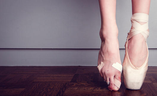 Young ballerina practicing dance moves on black background. Space for text