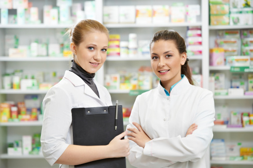 Two cheerful pharmacist chemist woman standing in pharmacy drugstore