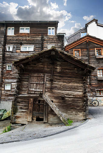 Zermatt, Switzerland - July 5, 2022: Nestled between hotels and shops in Zermatts centre the Hinterdorfstrasse is a charming quiet cobbled street & the oldest part of the village. Many of the buildings date back to the 1700s. Hinterdorf is now a listed & protected area.
