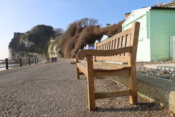 istock a wooden bench is facing the ocean and a green building 1776831944