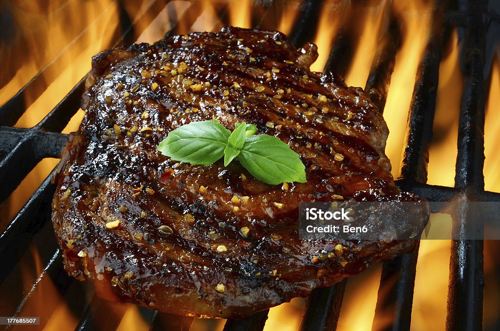 Entrecot en una barbacoa a la parrilla con llamas - Foto de stock de Aire libre libre de derechos