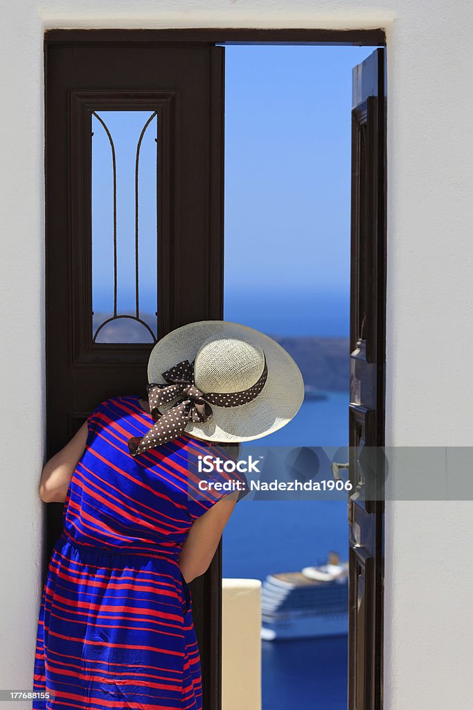 Kobieta otwarcia drzwi z widokiem na morze, koncepcja wakacje - Zbiór zdjęć royalty-free (Architektura)