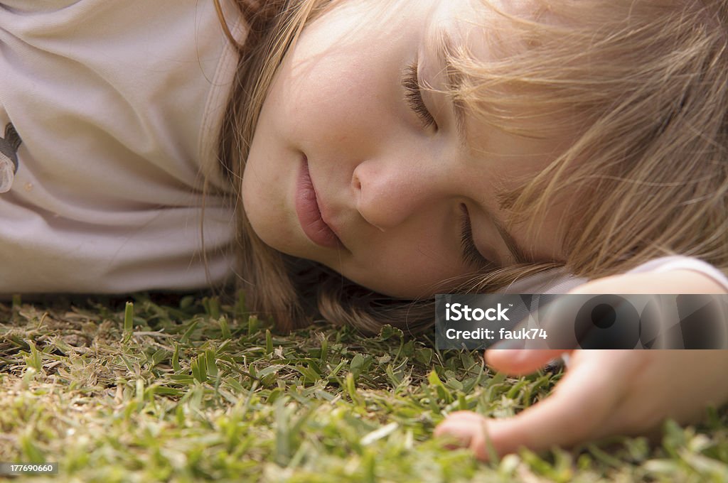 Niña durmiendo sobre la hierba - Foto de stock de 4-5 años libre de derechos