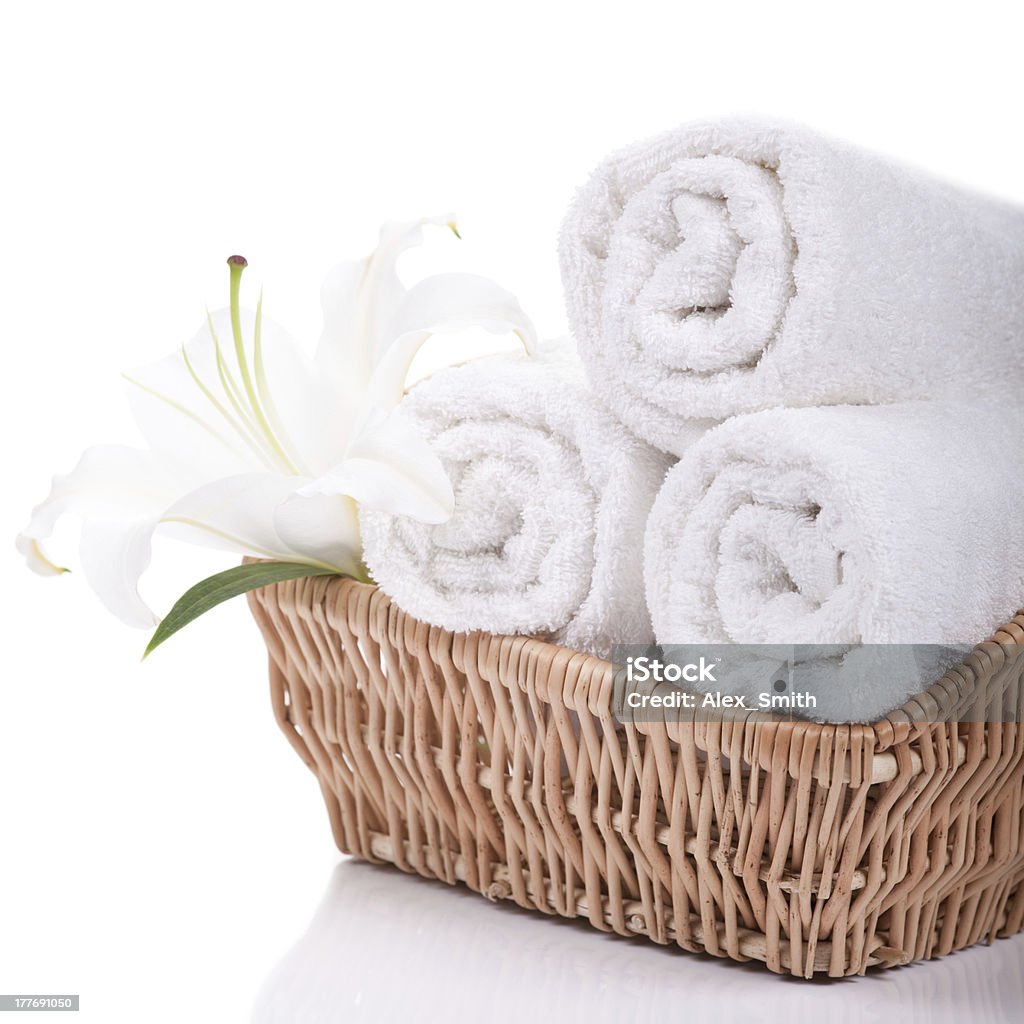 Towels with lilly Beautiful lilly on towels rolls isolated on white Basket Stock Photo