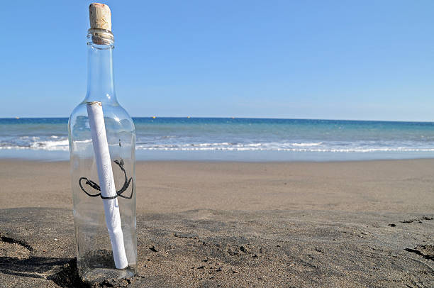 mensaje en una botella y playa solitaria - correspondence waving horizontal outdoors fotografías e imágenes de stock