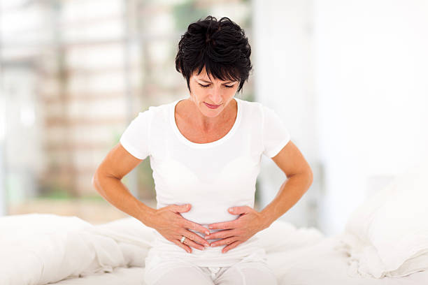 mid age woman having stomach pain stock photo