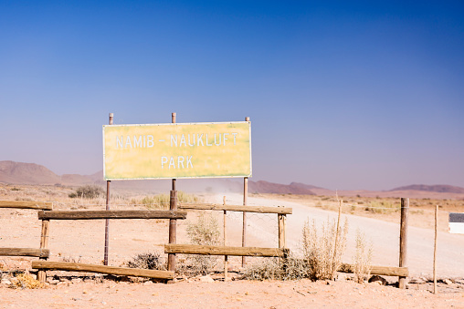 Worn out, old sign at the entrance of the Namib-Naukluft Park, Namibia.