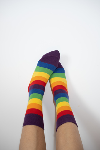 vertical closed shot with copy space of female legs with lgbt homosexual flag socks. concept of inclusivity and respect for diversity and sexual orientation.
