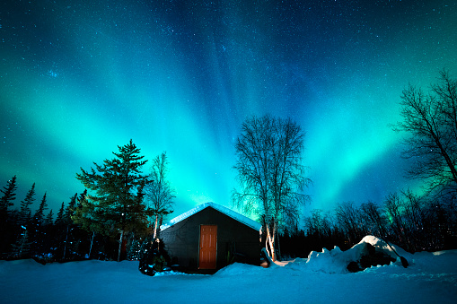 Aurora Borealis, northern lights, above a cabin on a freezing cold winter night in the Northwest Territories, Yellowknife, Alberta, Canada