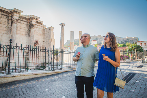Couple enjoying sightseeing The Library of Hadrian in Athens, Greece