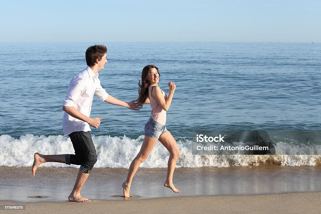 Couple chasing and running on the beach - Royalty-free Aanhankelijk Stockfoto Couple chasing and running on the beach - Royalty-free Aanhankelijk Stockfoto