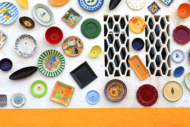 Colorful display of hand painted plates covers the outside wall of an artisan shop in Vila Do Bispo, Algarve, Portugal, Europe,