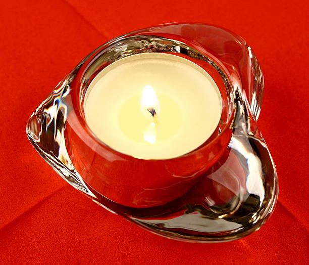 istock Glass heart with a candle on  red background closeup 177702650