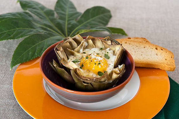 artichoke with egg in a bowl stock photo