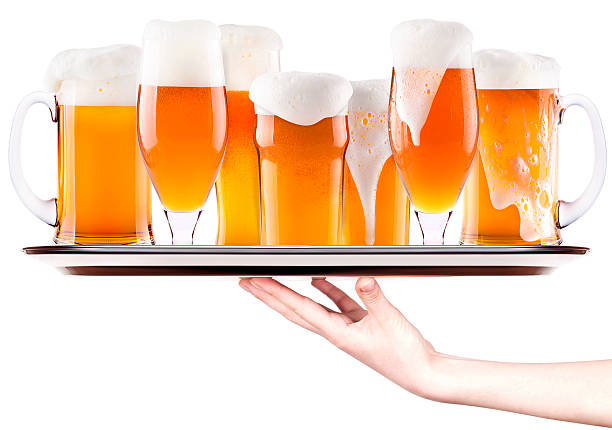 Frosty fresh beer with foam on a silver tray with waitress hand isolated