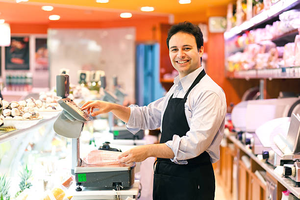 Smiling store keeper in his supermarket Portrait of a worker in a grocery store baloney photos stock pictures, royalty-free photos & images
