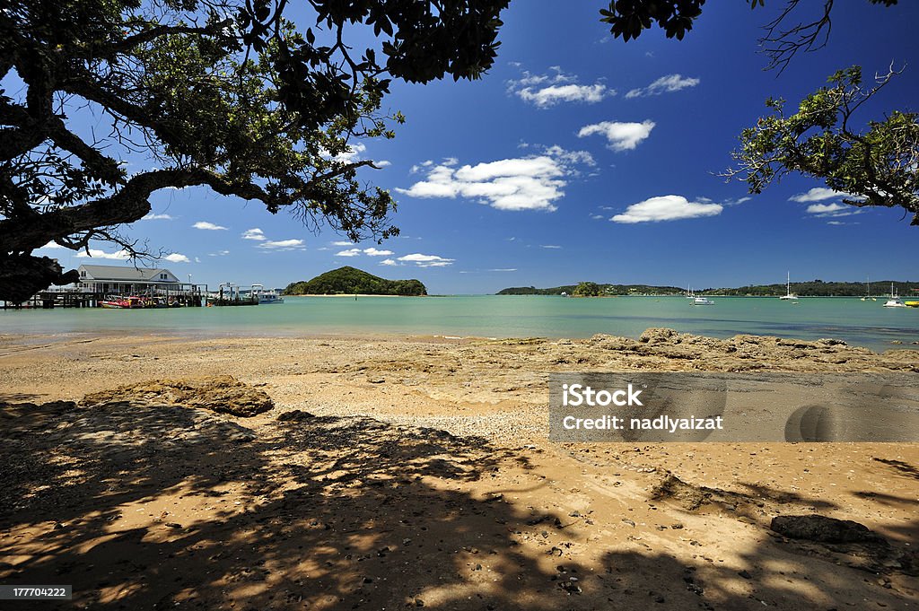 Beach near Township of Paihia, New Zealand. View of the beach near Paihia Wharf during afternoon. Paihia is the famous tourist attraction in Bay of Islands, New Zealand. Paihia Stock Photo