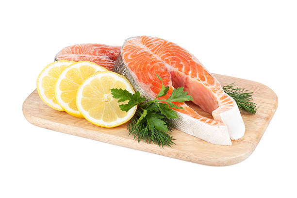 istock Salmon steaks on cutting board with lemons and herbs 177704701