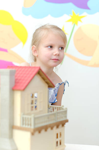 istock Little girl playing with dollhouse 177705258