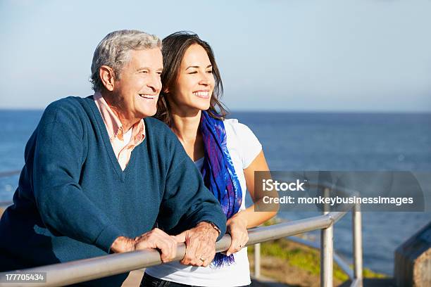 Senior Man With Adult Daughter Looking Over Railing At Sea Stock Photo - Download Image Now