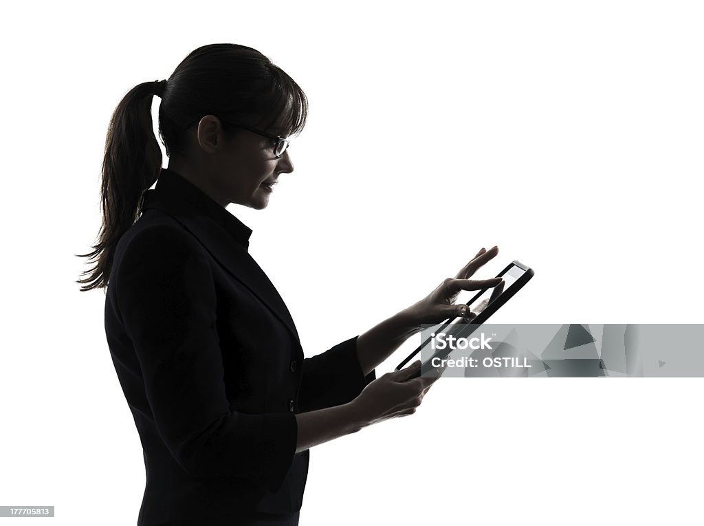 Silhouette of a woman using a table over a white background one business woman computer computing typing digital tablet  silhouette studio on white background In Silhouette Stock Photo