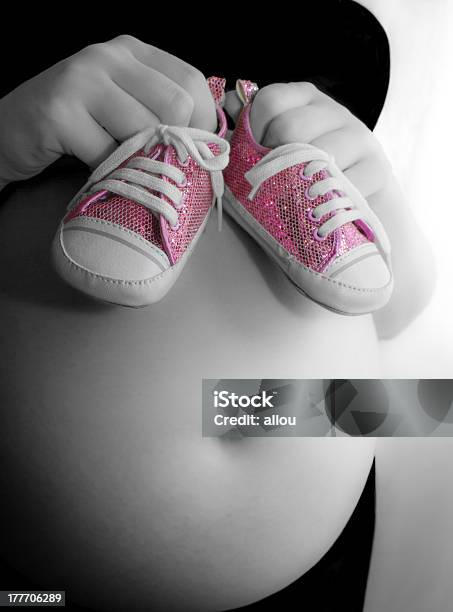 Pregnant Girl Holds Funky Pumps Up To Bump Stock Photo - Download Image Now - Adult, Adults Only, Baby Booties