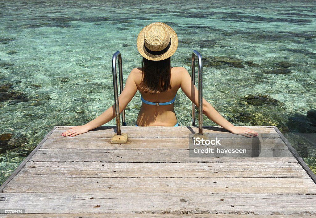 Donna su un molo spiaggia a Maldive - Foto stock royalty-free di Abbronzatura