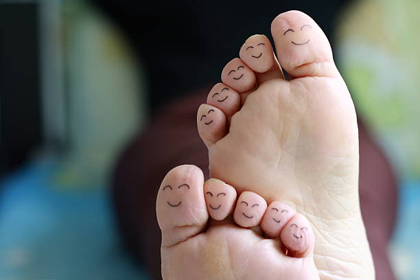 Close-up photo of feet with happy faces drawn on stock photo