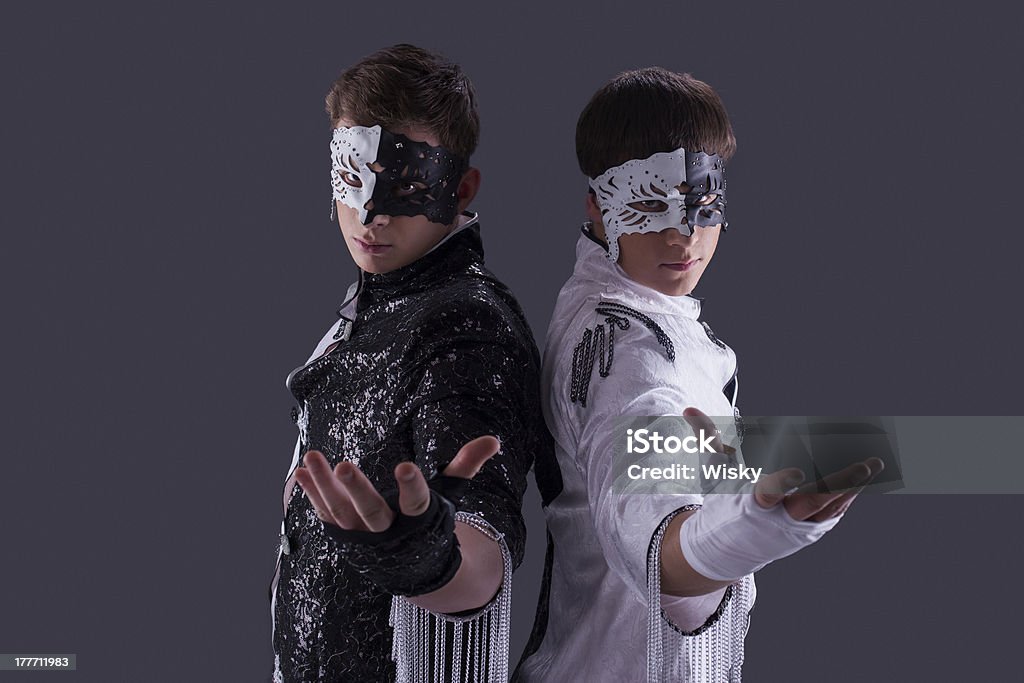 Portrait of attractive young guys in masks Portrait of attractive young guys in masks, on gray background Adult Stock Photo