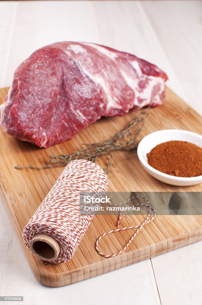 Blocco di carne cruda e spezie, erbe aromatiche e spaghi - Foto stock royalty-free di Allacciare