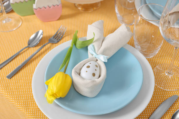 istock Festive table setting with painted egg, plate and tulip flower. Easter celebration 1777145045